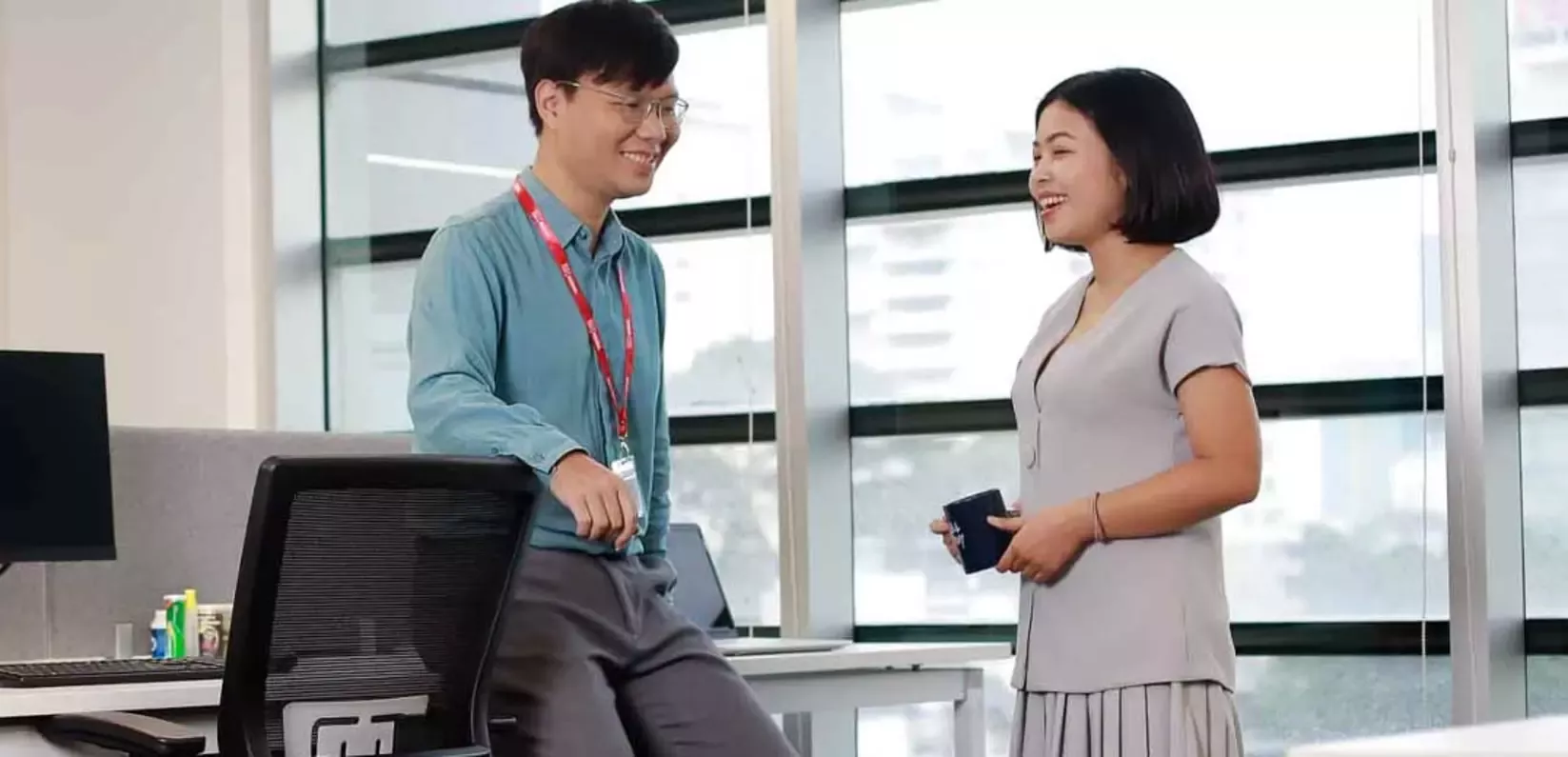 A man and woman are at a desk in an office